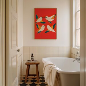 May include: A white bathroom with a freestanding bathtub, a wooden stool, and a framed print of stylized birds on a red background.