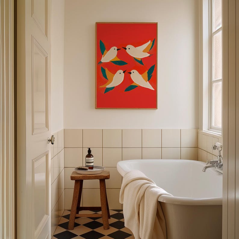 May include: A white bathroom with a freestanding bathtub, a wooden stool, and a framed print of stylized birds on a red background.