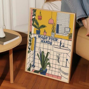 Può includere: Un bagno giallo e bianco con un lavandino, un water e piante. Il testo "WASH YOUR HANDS" è scritto in lettere blu sul muro.