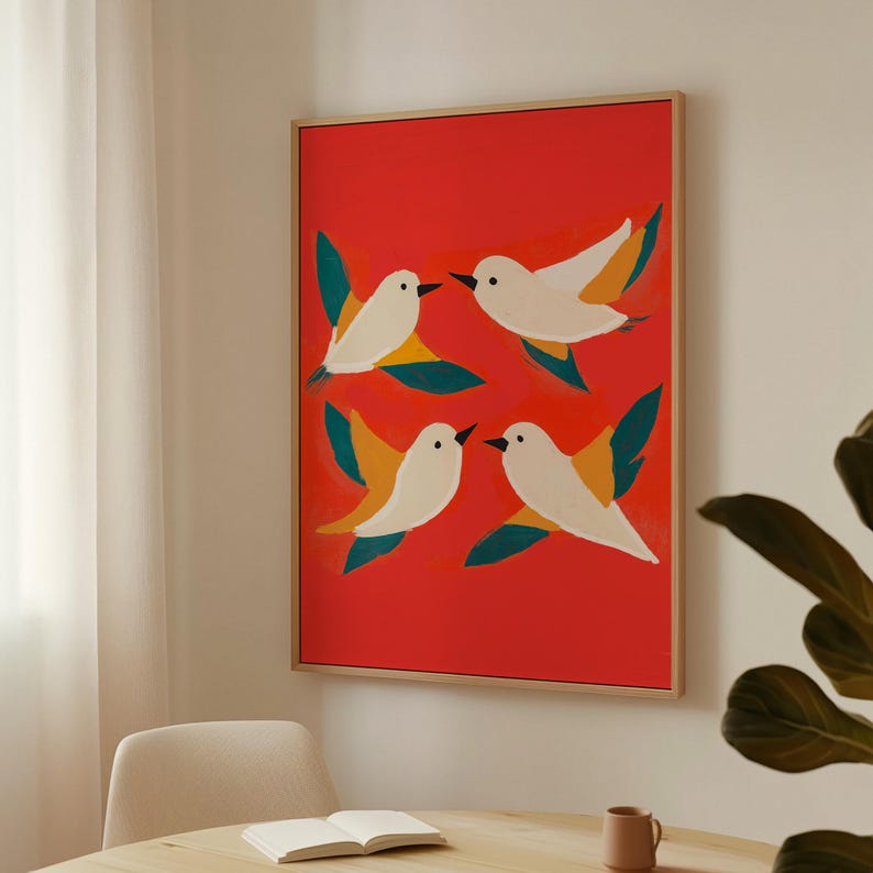 May include: A framed art print featuring four white birds with yellow and green accents flying against a red background.