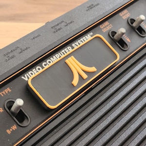 Atari 2600 / 2600+ カートリッジ スロット ダスト カバー - ロゴ 4 スイッチ バージョン - オレンジ
