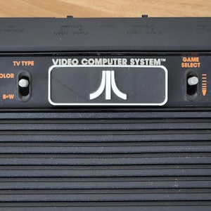 Atari 2600 / 2600+ カートリッジ スロット ダスト カバー - ロゴ 4 スイッチ バージョン - BW
