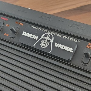 Atari 2600 / 2600+ カートリッジ スロット ダスト カバー - ダース ベイダー バージョン - ロゴ/テキスト