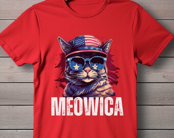 May include: Red t-shirt with a cartoon cat wearing sunglasses and a hat with an American flag design. The text "MEOWICA" is printed below the cat.