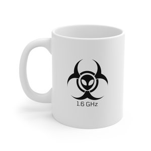 May include: White ceramic mug with a black alien biohazard symbol and the text "1.6 GHz" printed on the front.