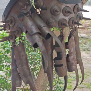 Pu&ograve; includere: Un guanto di metallo arrugginito con lunghe lame ricurve e borchie. Il guanto ha un cinturino in pelle ed &egrave; collegato a diverse lame articolate a forma di dita. Il design suggerisce un'arma o un elemento di costume.