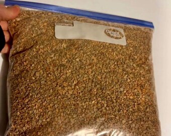 Pode incluir: Um saco de armazenamento de plástico transparente com fecho azul contendo uma mistura de solo granulado para suculentas. O saco apresenta uma área de etiqueta branca e o texto 1 Gallon bag Succulent Soil Mix 5 lbs em vermelho.
