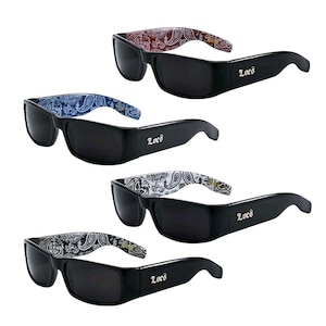 May include: Four pairs of black sunglasses with different paisley patterned frames. The sunglasses have black lenses and the word "Loco" is printed on the side of the frames.