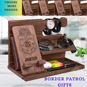 May include: A wooden phone stand with a leather wallet, watch holder, glasses holder, and key holder. The stand is engraved with the words "CBP Border Patrol" and "U.S. Patrol Agent".