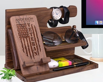 May include: A wooden desk organizer with multiple compartments for holding items like a watch, phone, keys, and sunglasses. The organizer has a personalized inscription that reads "Anderson 02.18.1974 Veteran" with an American flag design.