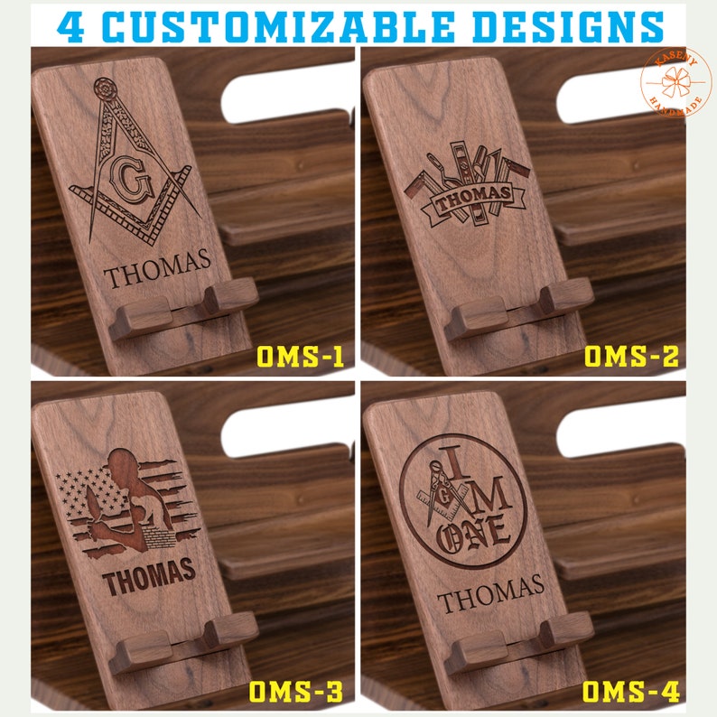 May include: Four customizable wooden phone stands with different engraved designs. The designs include a compass and square, tools, an American flag, and a compass and square with the words "I am one". Each stand has the name "Thomas" engraved below the design.