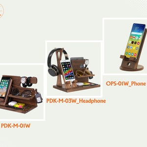 May include: Three wooden phone and accessory stands. The stand on the left has a phone, glasses, a watch, and a key. The middle stand has a phone, headphones, and a watch. The stand on the right has a phone.