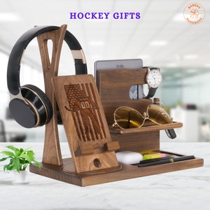 Puede incluir: Un organizador de madera con un dise&ntilde;o de jugador de hockey, que incluye ranuras para un tel&eacute;fono, un reloj, gafas y otros art&iacute;culos. El organizador tambi&eacute;n tiene un soporte para auriculares y un peque&ntilde;o estante para un Kindle.