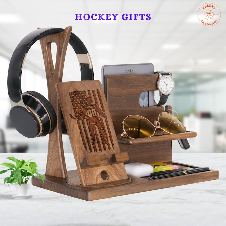 Puede incluir: Un organizador de madera con un dise&ntilde;o de jugador de hockey, que incluye ranuras para un tel&eacute;fono, un reloj, gafas y otros art&iacute;culos. El organizador tambi&eacute;n tiene un soporte para auriculares y un peque&ntilde;o estante para un Kindle.