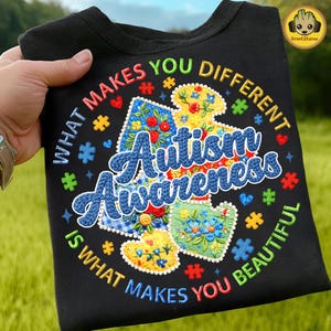 May include: Black sweatshirt with the text "What Makes You Different Is What Makes You Beautiful" surrounding the words "Autism Awareness". The design includes puzzle pieces and floral patterns in various colors.