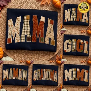 May include: A collection of dark navy blue sweatshirts featuring large, block-letter appliqués in various autumn-themed patterns, including plaid, leopard print, and floral designs. The shirts display words such as MAMA, NANA, GIGI, MAMAW, GRANDMA, and MIMI.