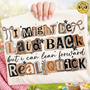 May include: Cream-colored t-shirt with the text "I might be laid back but I can lean forward real quick." The text is in a collage style with leopard print accents and star details. A bow is on the top left and right.
