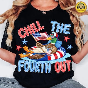 May include: Black t-shirt with a graphic of a duck in sunglasses and a patriotic floatie, holding an American flag and a can of "Freedom Ale." Text reads "Chill the Fourth Out" in red and blue.