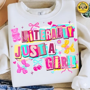 以下が含まれることがあります： 「LITERALLY JUST A GIRL」の文字がカラフルなブロック体でプリントされた白いスウェットシャツ。ピンクのグミベア、風船の動物、さくらんぼ、リボン、ハート、花などのデザイン。楽しくて遊び心のあるグラフィック。