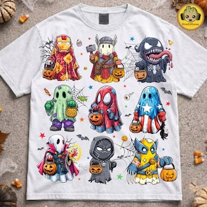 May include: A white short-sleeve t-shirt featuring a graphic print of nine cartoon characters dressed as ghosts for Halloween. Each character wears a costume inspired by a superhero and carries a small orange jack-o'-lantern candy bucket.