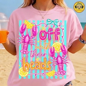 以下が含まれることがあります： ピンク色のTシャツ。2匹のピンク色のロブスター、レモンスライス、そして「Off with their heads」というテキストが特徴的なグラフィックデザイン。 ターコイズのストライプと装飾的な要素が含まれています。