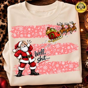 May include: A cream-colored sweatshirt featuring a graphic of Santa Claus with his hand on his forehead, looking at a flying sleigh pulled by three reindeer. The design includes pink horizontal stripes with white snowflakes and the text Well, shit...
