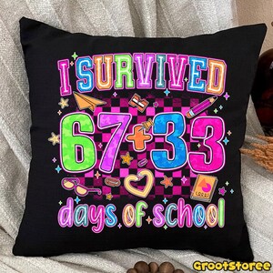 May include: Black throw pillow with the text "I SURVIVED 67+33 days of school" in colorful, playful lettering. The design includes stars, a paper airplane, a pencil, and other school-themed graphics. The pillow has a checkered background.