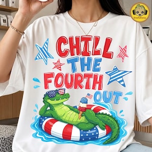 May include: White t-shirt with a graphic featuring a green alligator wearing sunglasses and floating on a red, white, and blue inner tube. The text reads "CHILL THE FOURTH OUT" with star and water drop accents.
