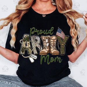 May include: Black t-shirt with a green, white, and red camouflage design. The text "Proud Army Mom" is written in green letters. A small American flag is in the upper right corner. The text "Olivia" is written on a dog tag.