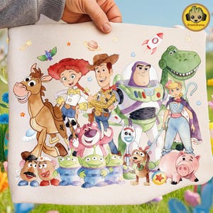 Puede incluir: Una tela beige con una colorida ilustración de personajes de la película animada Toy Story. La imagen incluye a Woody, Buzz Lightyear, Jessie, Rex y otros personajes. El fondo tiene estrellas, planetas y un cohete.