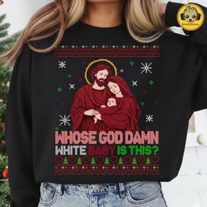 May include: Black crew neck sweatshirt with a Christmas sweater design. The graphic features a religious family portrait with the text "WHOSE GOD DAMN WHITE BABY IS THIS?" in white and pink.