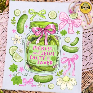 May include: A white decorative kitchen towel featuring a jar of pickles with a pink bow and the text "Pickles and Jesus Salty & Saved." The design includes green pickles, cucumber slices, and decorative bows.