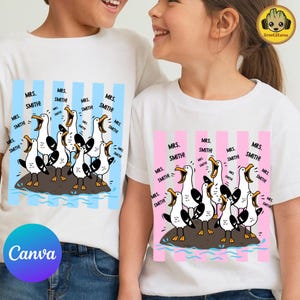 May include: Two white t-shirts featuring a graphic of seagulls on a rock with the text "MRS. SMITH!" repeated multiple times. One shirt has light blue vertical stripes, and the other has light pink vertical stripes behind the seagull illustration.