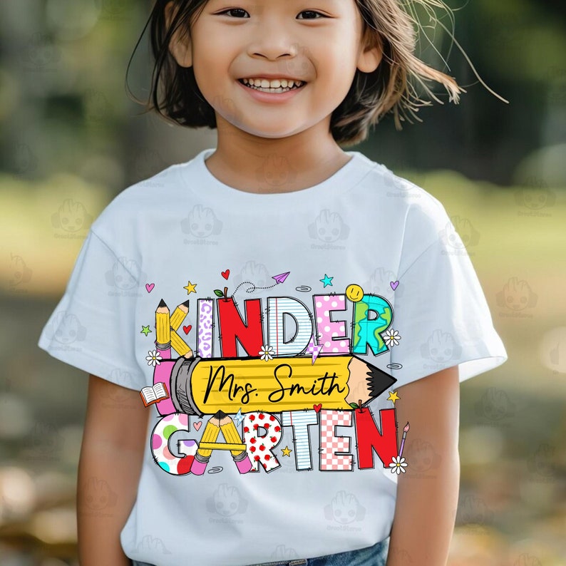 May include: A white t-shirt with a colourful graphic that says "Kindergarten" with a pencil and the text "Mrs. Smith" on it.