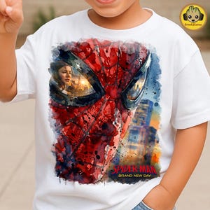 May include: A white short-sleeved t-shirt featuring a watercolour-style graphic of Spider-Man's mask. The mask's lenses reflect a city skyline and a person's face. The text "SPIDER-MAN BRAND NEW DAY" is printed in red and yellow at the bottom.