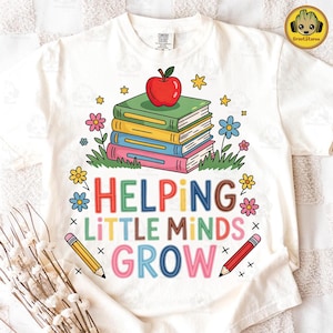 May include: White t-shirt featuring a colorful graphic design. The design includes a stack of books topped with a red apple, flowers, stars, and the text "HELPING LITTLE MINDS GROW" in various colors. Two pencils are also included.