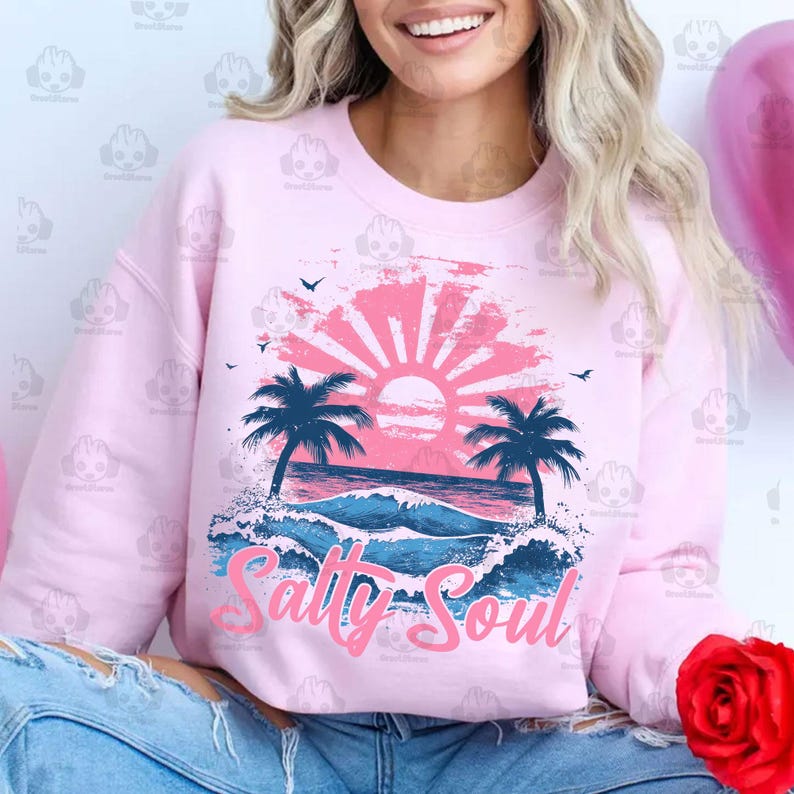May include: Pink sweatshirt with a graphic of a sunset over a beach with palm trees and the text "Salty Soul".