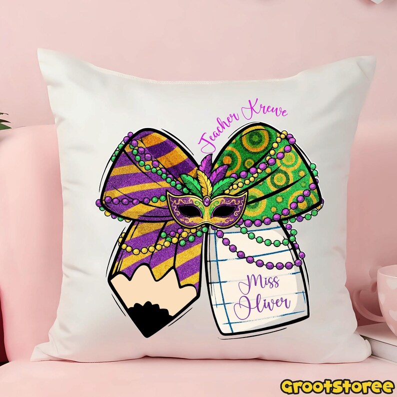 May include: White square pillow with a colorful Mardi Gras design. The design includes a purple and gold bow, a mask, and a pencil. The text "Teacher Krewe" and "Miss Oliver" are also visible.
