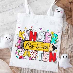 May include: White canvas tote bag with a colourful design that says "Kindergarten" with a pencil and the name "Mrs. Smith".