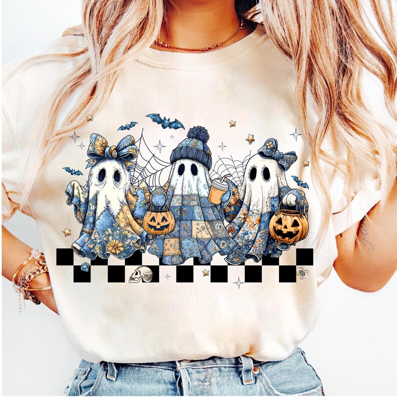 K&ouml;nnte beinhalten: Cremefarbenes Sweatshirt mit einem Halloween-Motiv von drei Cartoon-Geistern. Die Geister sind in Patchwork- und floral gemusterte T&uuml;cher geh&uuml;llt und halten K&uuml;rbislaternen und eine Kaffeetasse. Flederm&auml;use, Sterne und Spinnweben vervollst&auml;ndigen das Design.