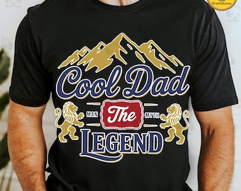 May include: Black t-shirt with a graphic design featuring a mountain range, two lions, and the text "Cool Dad The Legend".