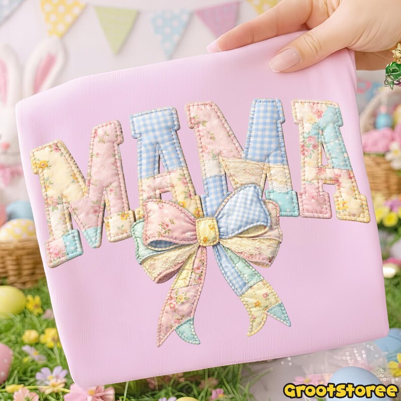 Puede incluir: Un bolso tote rosa claro con la palabra "MAMA" aplicada en un dise&ntilde;o de patchwork. Las letras presentan patrones florales y de cuadros, con un gran lazo en la parte inferior. El bolso es sostenido por una persona.
