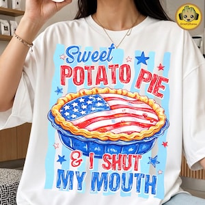 May include: White t-shirt with a graphic of a sweet potato pie designed as an American flag. The text reads "Sweet Potato Pie & I Shut My Mouth" in red and blue. The pie is in a blue pie dish with a golden crust.