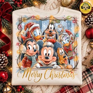 Puede incluir: Una camiseta color crema con un gráfico de Mickey Mouse, Minnie Mouse, Donald Duck, Daisy Duck, Goofy y Pluto con ropa de invierno. Los personajes están enmarcados por luces navideñas y el texto Merry Christmas en letras doradas.