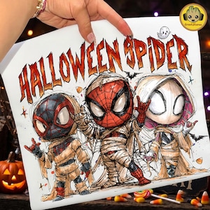 May include: A white graphic print featuring the text HALLOWEEN SPIDER in orange and red letters. The design displays three stylized superhero characters wrapped in bandages like mummies, with large eyes and spider-themed suits, alongside a small ghost.