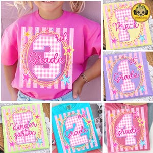 May include: A bright pink t-shirt featuring a large graphic with a white and pink gingham number three, the text 3rd Grade, and colorful stars. The design is set against a background of vertical stripes and a decorative circular frame.
