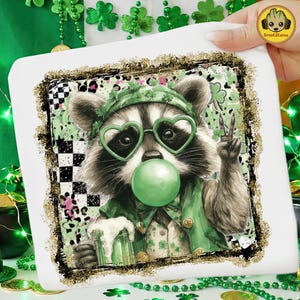 May include: A white square featuring a raccoon wearing heart-shaped glasses and a green outfit, blowing a bubble. The raccoon is holding a beer and giving a peace sign. The image has a gold and black border with green shamrocks.