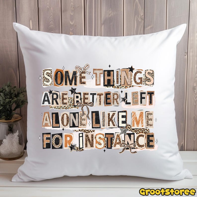 Puede incluir: Coj&iacute;n cuadrado blanco con el texto "SOME THINGS ARE BETTER LEFT ALONE LIKE ME FOR INSTANCE" en una mezcla de fuentes y patrones, incluyendo estampado de leopardo y estrellas. El coj&iacute;n tiene lazos decorativos.