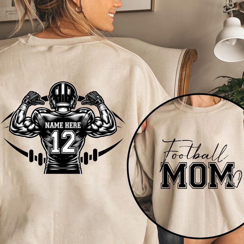 May include: Beige sweatshirt featuring a football player graphic on the back with the text "NAME HERE" and the number 12. A smaller image shows the text "Football MOM" with a football heart.