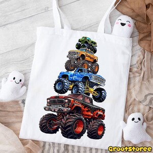 May include: White tote bag featuring a stack of five colorful monster trucks. The trucks are red, blue, orange, green, and black, with large tires and detailed graphics. The bag has two white handles and the text "GrootStoree" at the bottom.